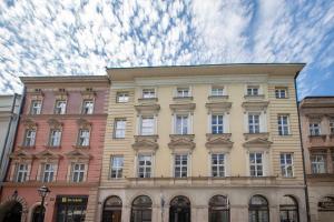 a building on a street with a cloudy sky at Slawkowska No 6 Residence in Krakow