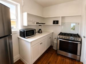 a kitchen with a microwave and a stove at Solea by The Sea in Roatán