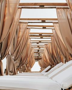 a row of tables in a room with curtains at THE ONE Grand Hotel da Póvoa - by MHMB Hospitality in Póvoa de Varzim