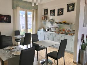 a dining room with tables and chairs and a kitchen at Bella Tropea Accommodation in Tropea
