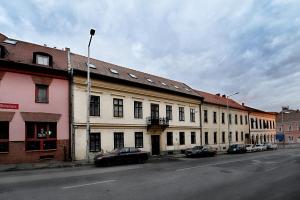 a row of buildings with cars parked on a street at Centrum Apartman in Pécs