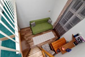 einen Blick über ein kleines Zimmer mit grünem Sofa in der Unterkunft Centrum Apartman in Pécs