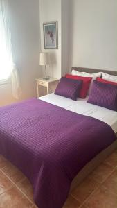 a large purple and white bed with pillows on it at andros prive suites in Kipri