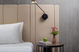 a bedroom with a bed and a table with a lamp at NH Pisa in Pisa