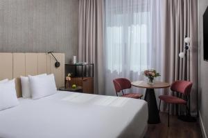 a hotel room with a bed and a table at NH Pisa in Pisa