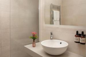 a bathroom with a white sink and a mirror at NH Pisa in Pisa +42 photos