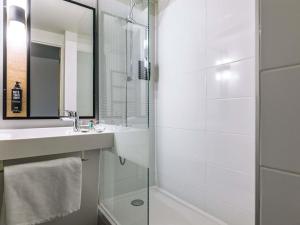 a bathroom with a shower and a sink and a mirror at ibis Metz Centre Cathedrale in Metz +32 photos