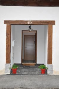 a front door of a building with two pots at Estudio con Rincón de Cortesía Pusantenea in Berástegui