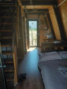 a bedroom with two beds and a staircase in a room at Cozy Lakefront Cabin - Myselim in Shkodër