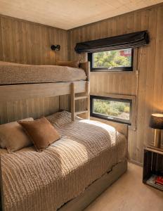 a bedroom with two bunk beds and a window at Peaceful lakefront cabin in Tjaldal