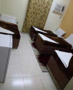 a room with three beds sitting on the floor at فندق المرجان للخدمات الفندقية in Jarwal