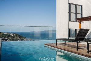a chair sitting on the edge of a swimming pool at Modern Condominium w/ Sea View Pool, Itapema - MHFB in Itapema