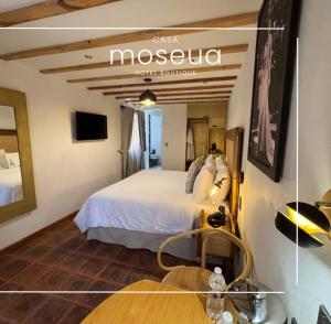 a hotel room with a bed and a table at Casa Moseua Hotel Boutique de Autor in Querétaro