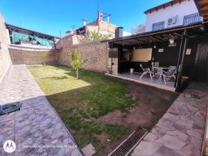a backyard with a patio with a table and chairs at Casa Milo in Mendoza
