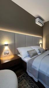 a hotel room with two beds and a table with lights at Hotel Jelen in Hlohovec