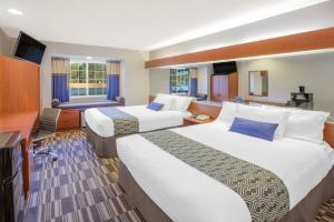 um quarto de hotel com duas camas e uma secretária em Microtel Inn and Suites Manistee em Manistee