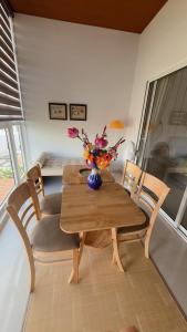 a dining room table with chairs and a vase with flowers at CoGiang Homestay in Thôn Lại Thê