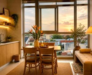 a kitchen with a table and chairs in front of a window at CoGiang Homestay in Thôn Lại Thê