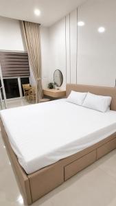 a bedroom with a large white bed in a room at CoGiang Homestay in Thôn Lại Thê