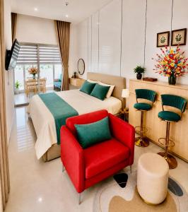 a bedroom with a bed and a red chair at CoGiang Homestay in Thôn Lại Thê