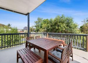 a wooden table and chairs on a balcony at Mindil Arch Walk to 3 Beaches & River in Tomakin