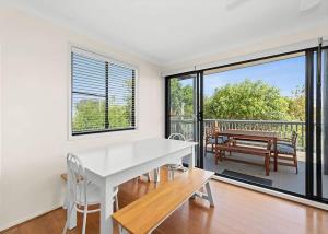 a white dining room with a white table and chairs at Mindil Arch Walk to 3 Beaches & River in Tomakin