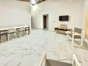 a room with a table and chairs and a tv at Mi Refugio 3 in Río San Juan