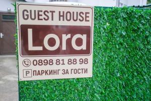 a sign for a guest house londa on a bush at Guest house LORA in Gabrovo