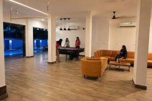a group of people in a living room with a pool table at Resort SH!VOM Phase-1 in Calangute