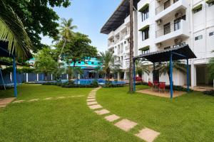 a walkway in the grass in front of a building at Resort SH!VOM Phase-1 in Calangute