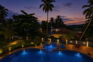 a view of a swimming pool at night at Resort SH!VOM Phase-1 in Calangute