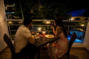 a man and a woman sitting at a table with a cake at Resort SH!VOM Phase-1 in Calangute