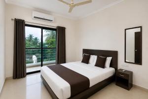 a bedroom with a large bed with a large window at Resort SH!VOM Phase-1 in Calangute +12 photos