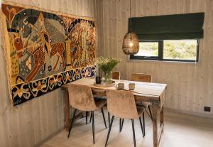 a dining room with a wooden table and chairs at Peaceful lakefront cabin in Tjaldal