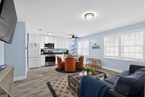 a living room with a couch and chairs and a kitchen at Steps to Sand Updated Bouchee Beachy Condo Deck Parking in Brigantine