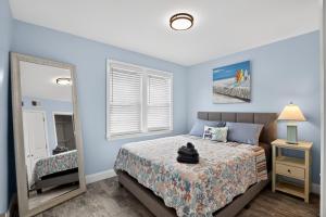 a bedroom with a large bed and a mirror at Steps to Sand Updated Bouchee Beachy Condo Deck Parking in Brigantine