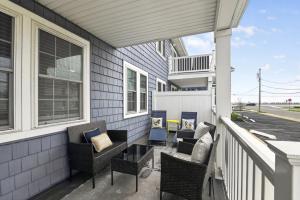a patio with chairs and a table on a balcony at Steps to Sand Updated Bouchee Beachy Condo Deck Parking in Brigantine