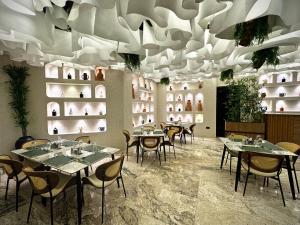 a restaurant with tables and chairs under a ceiling at Amazonia Luxury in Abuja