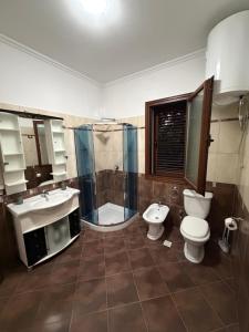 a bathroom with two sinks and a toilet and a shower at Comfort House in Bathore