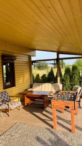 a screened in porch with a table and a couch at Ranczo Obozin 62 in Obozin