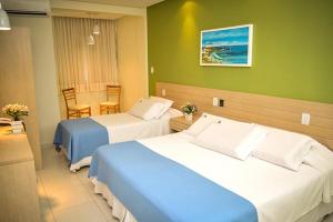 a hotel room with two beds and a table at Hit Hotel in Salvador +53 photos