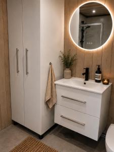 a bathroom with a white sink and a mirror at Peaceful lakefront cabin in Tjaldal +24 photos