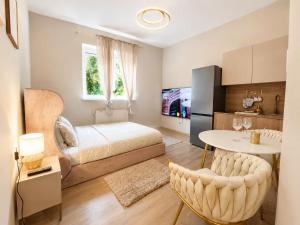 a bedroom with a bed and a table and a kitchen at Panorama Apartament in Poznań