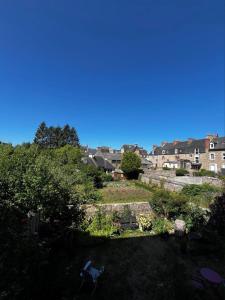 a view of a garden with buildings in the background at Guingamp studio with garden view in Guingamp