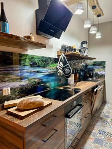 a kitchen with a counter with a loaf of bread on it at Osada Sielankowo - Kopiec in Żałe +15 photos