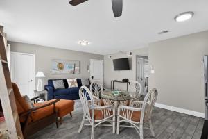 a living room with a table and chairs and a couch at Radiant Beach Block Condo Parking Patio in Brigantine