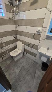 a bathroom with a toilet and a sink at Aura Suites Chernallur in Ernakulam +4 photos