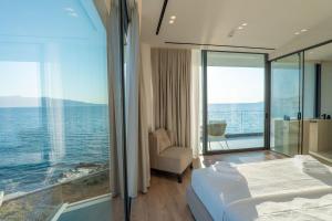 a bedroom with a bed and a view of the ocean at Nube Luxury Villas in Sarandë