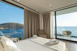 a bedroom with a bed and a view of the ocean at Nube Luxury Villas in Sarandë