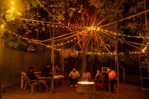 a group of people sitting under a tree with lights at Misty Hills Cabin in Wayanad +29 photos